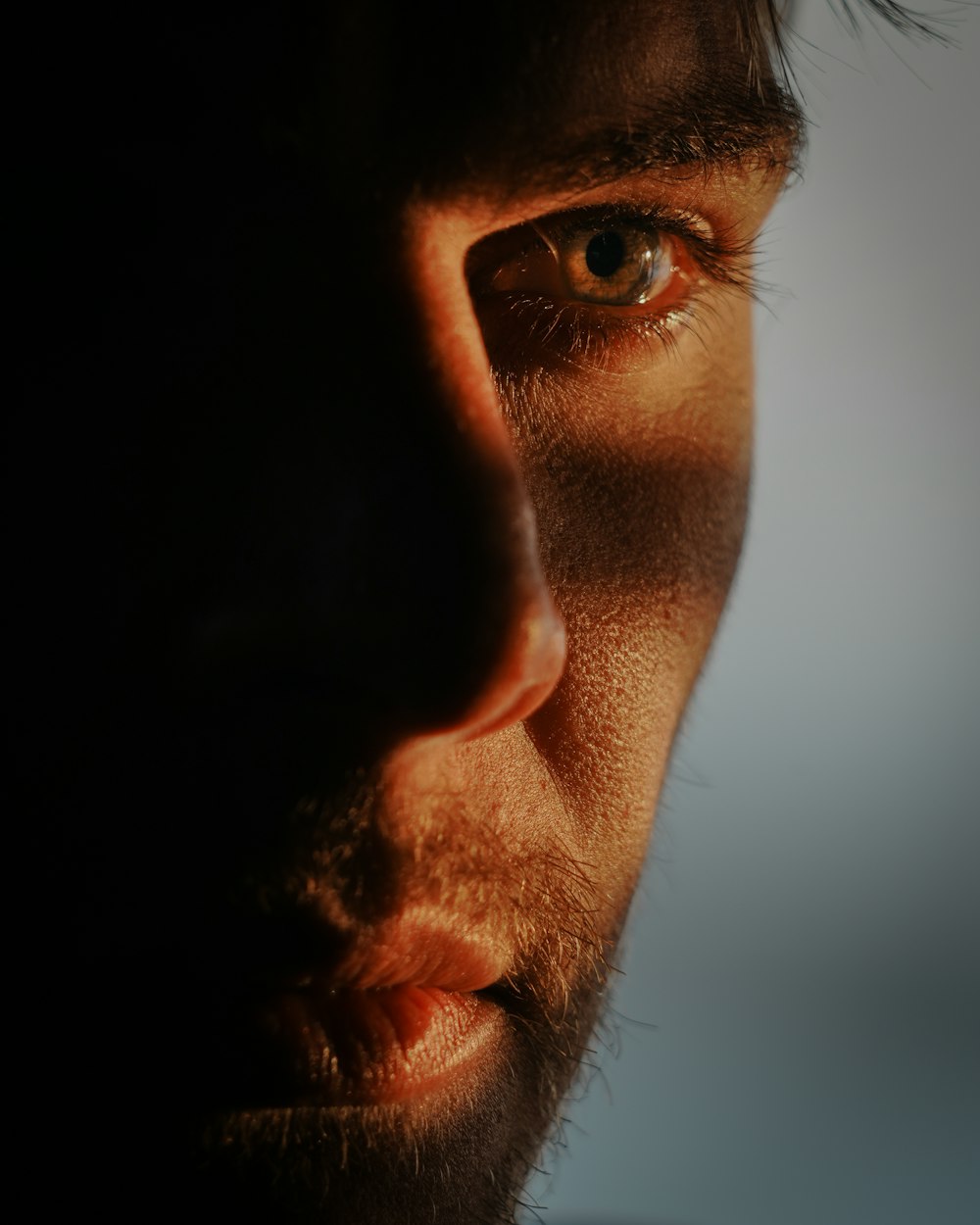 a close up of a man's face with a cell phone in his hand