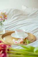 A serene setup of a glass teacup filled with pale golden white tea on a beige linen cloth.
