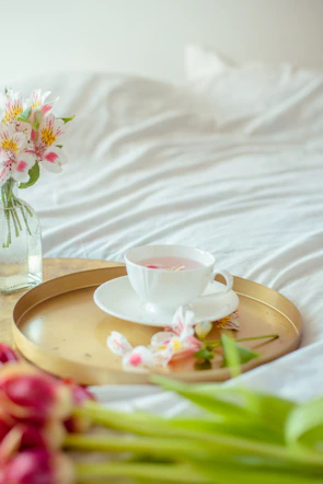 A serene setup of a glass teacup filled with pale golden white tea on a beige linen cloth.