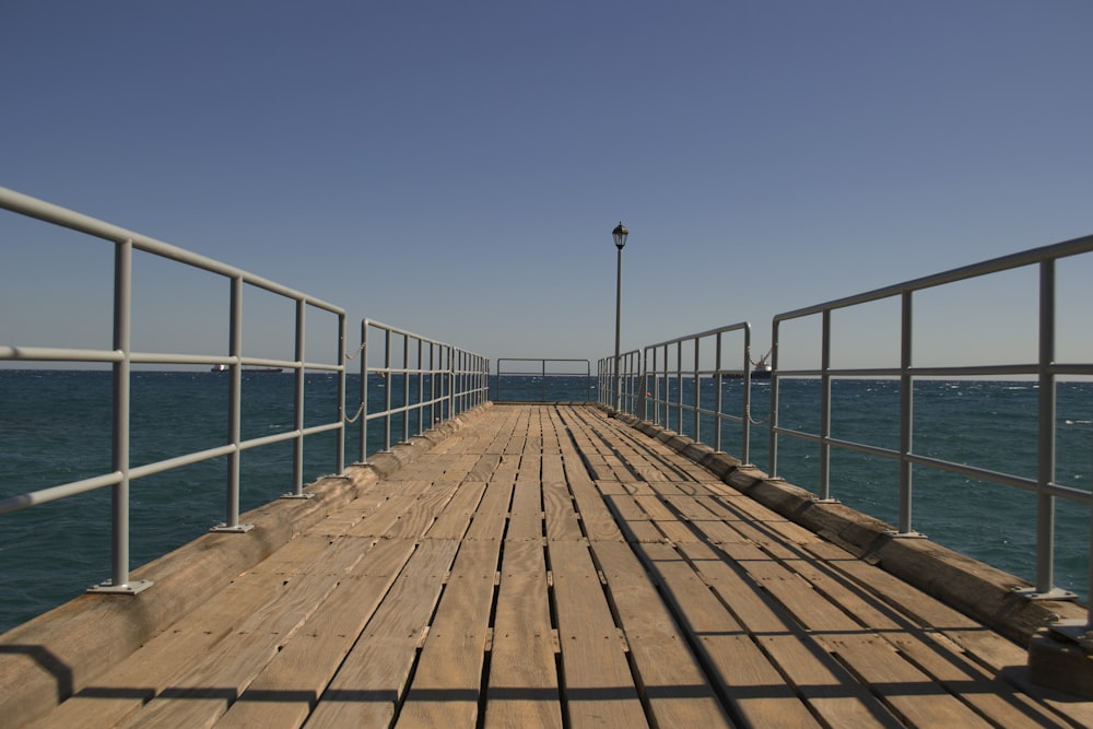 a long wooden pier with a light pole on top of it