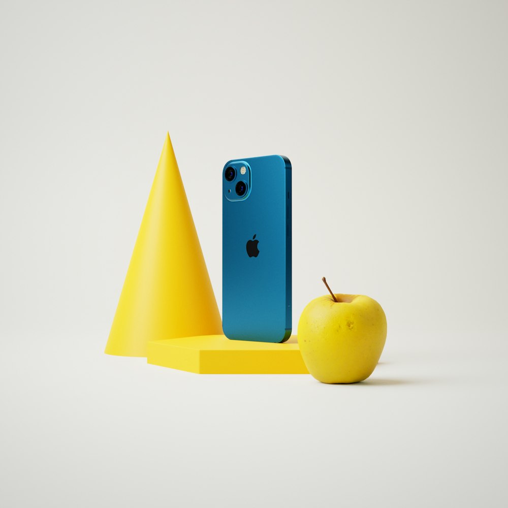 a blue iphone sitting next to a yellow apple