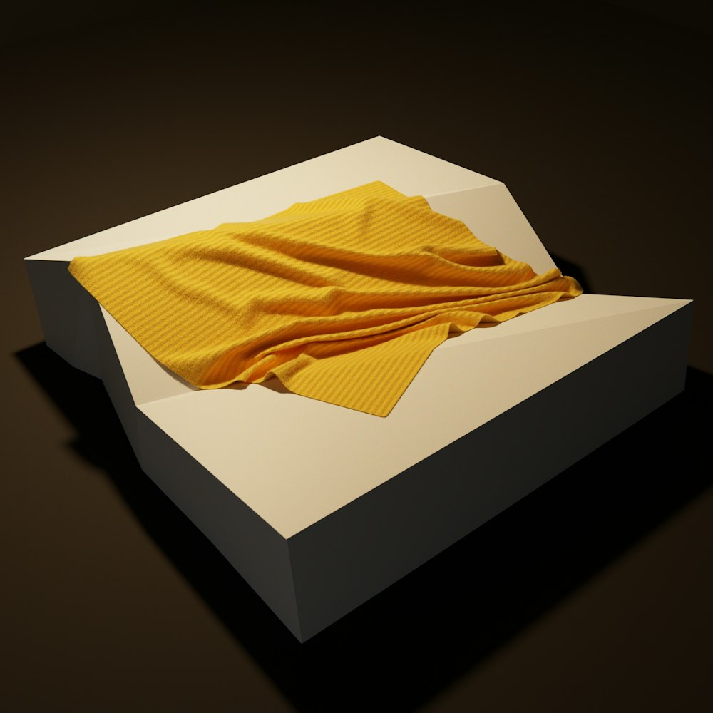 a folded yellow blanket in a white box