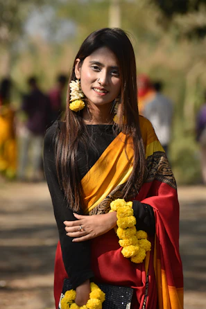 An outdoor shot of a woman twirling in a bright yellow saree with bold geometric designs.