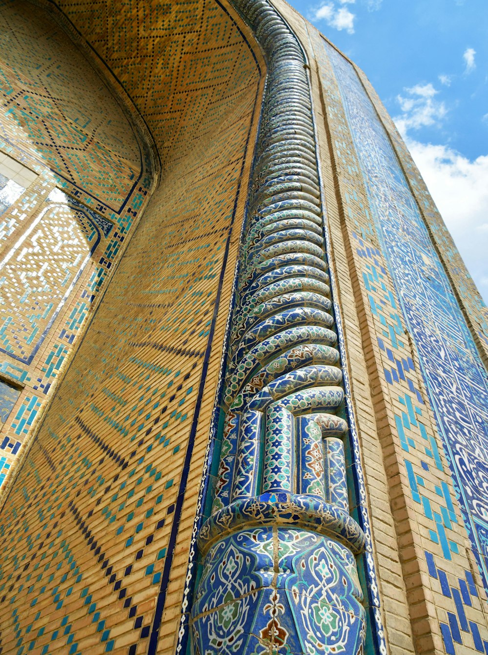 a tall building with blue and gold tiles on it