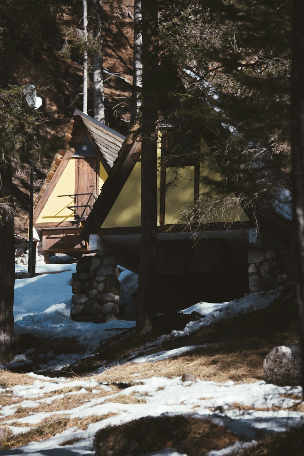 a cabin in the woods with snow on the ground