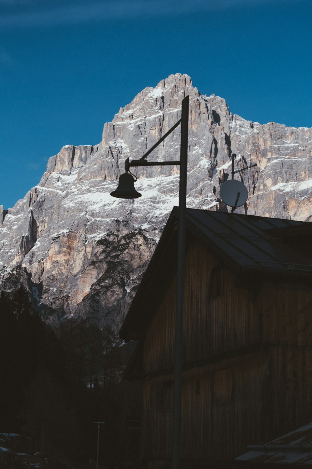 a mountain is in the background with a weather vane in the foreground