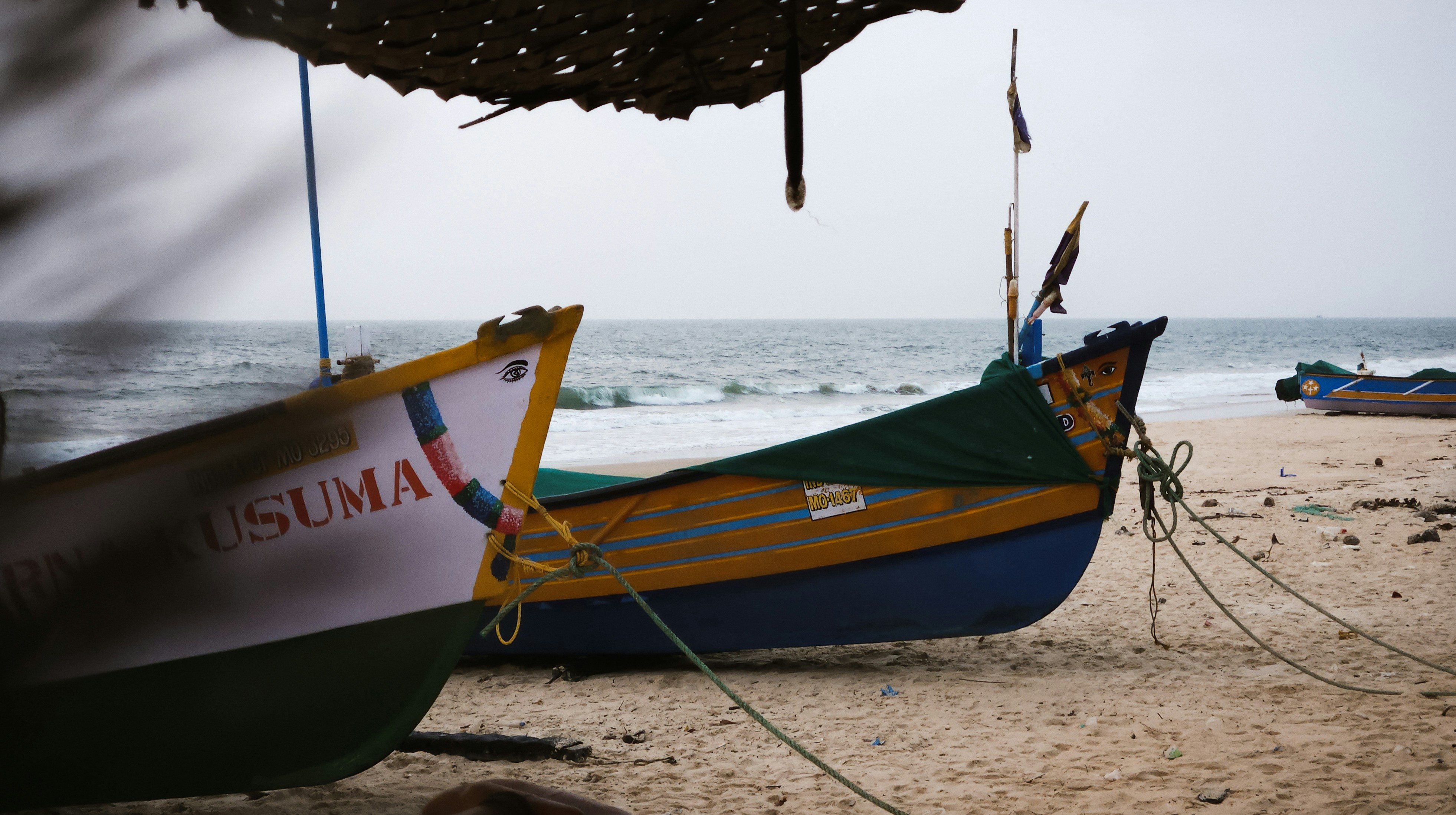 a couple of boats sitting on top of a sandy beach