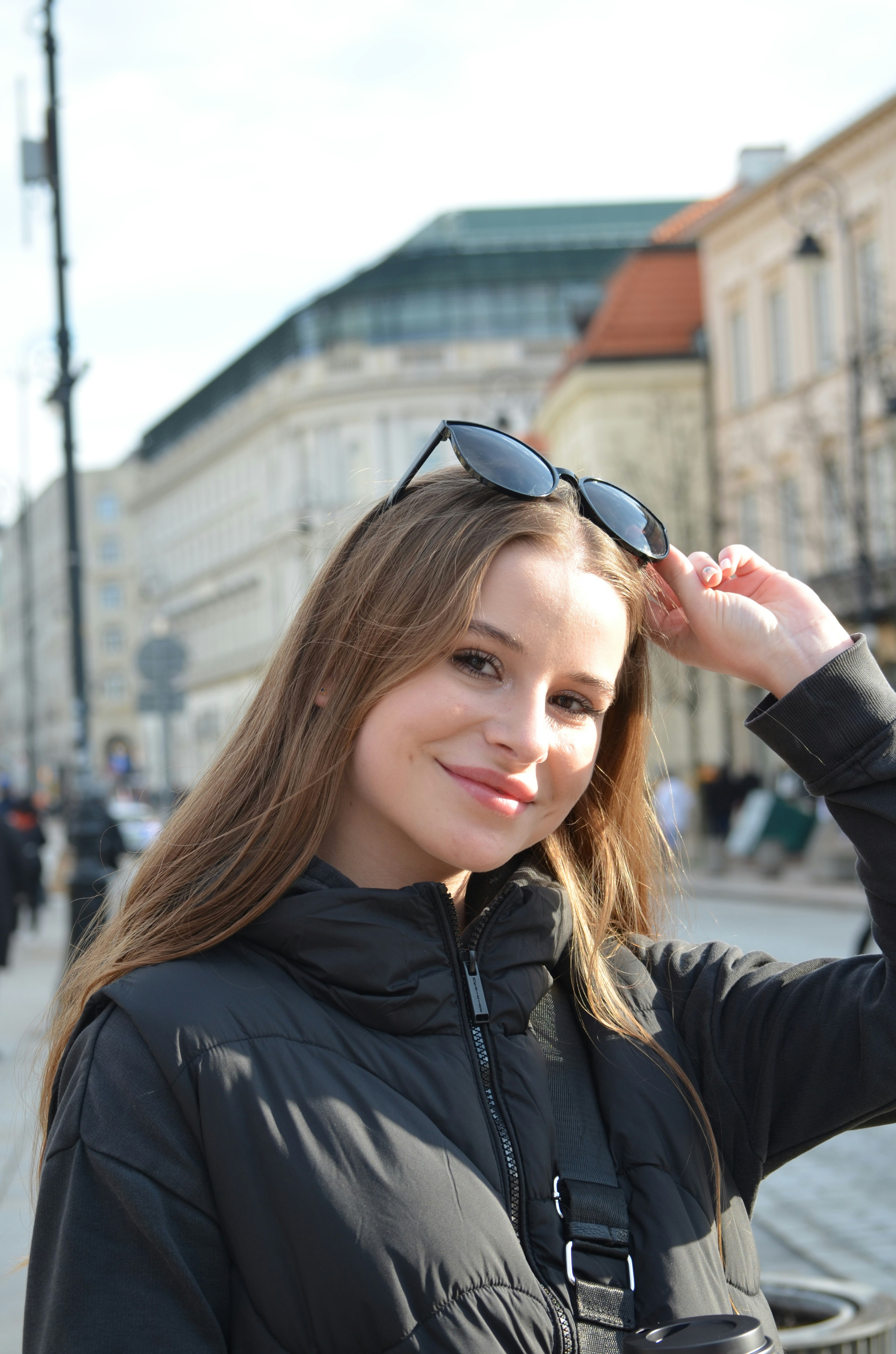 a woman in a black jacket and sunglasses