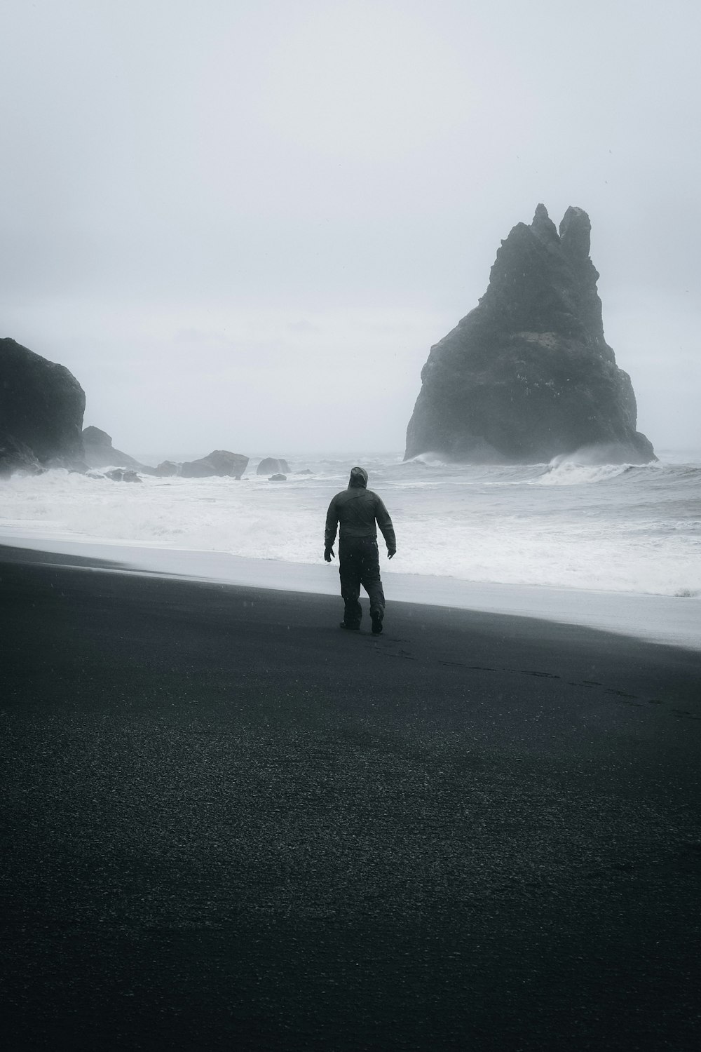 Ein Mann steht an einem Strand am Meer