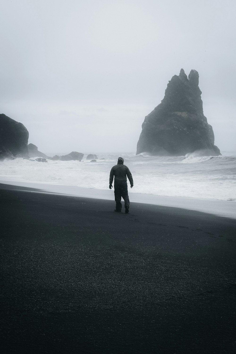 a man standing on a beach next to the ocean