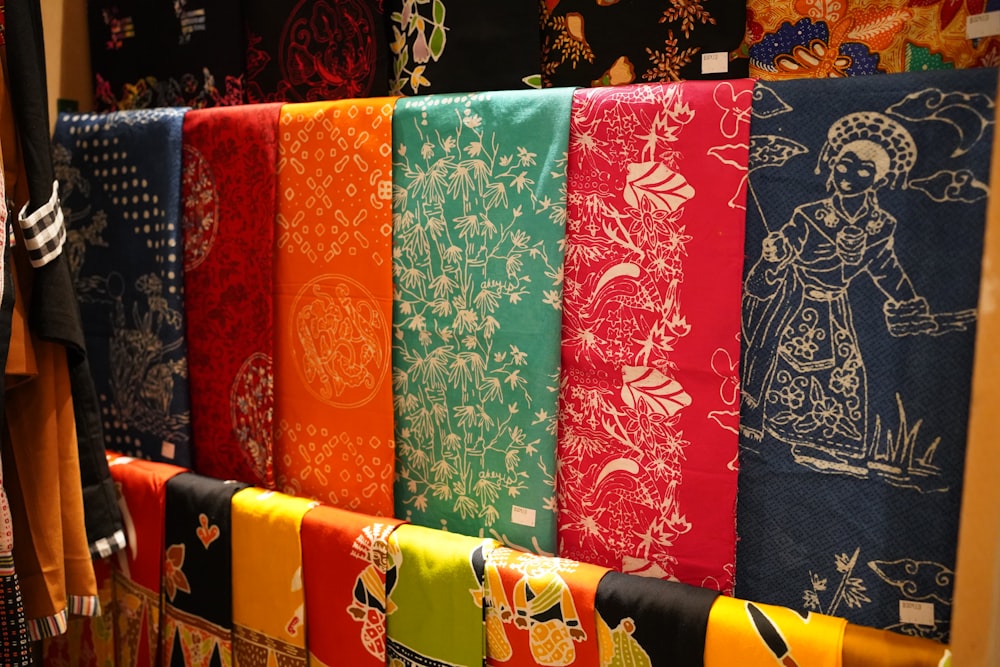 a row of colorful towels hanging on a wall