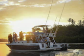 Guests enjoying a sunset cruise, wrapped in cozy blankets, with the golden light reflecting on the water.