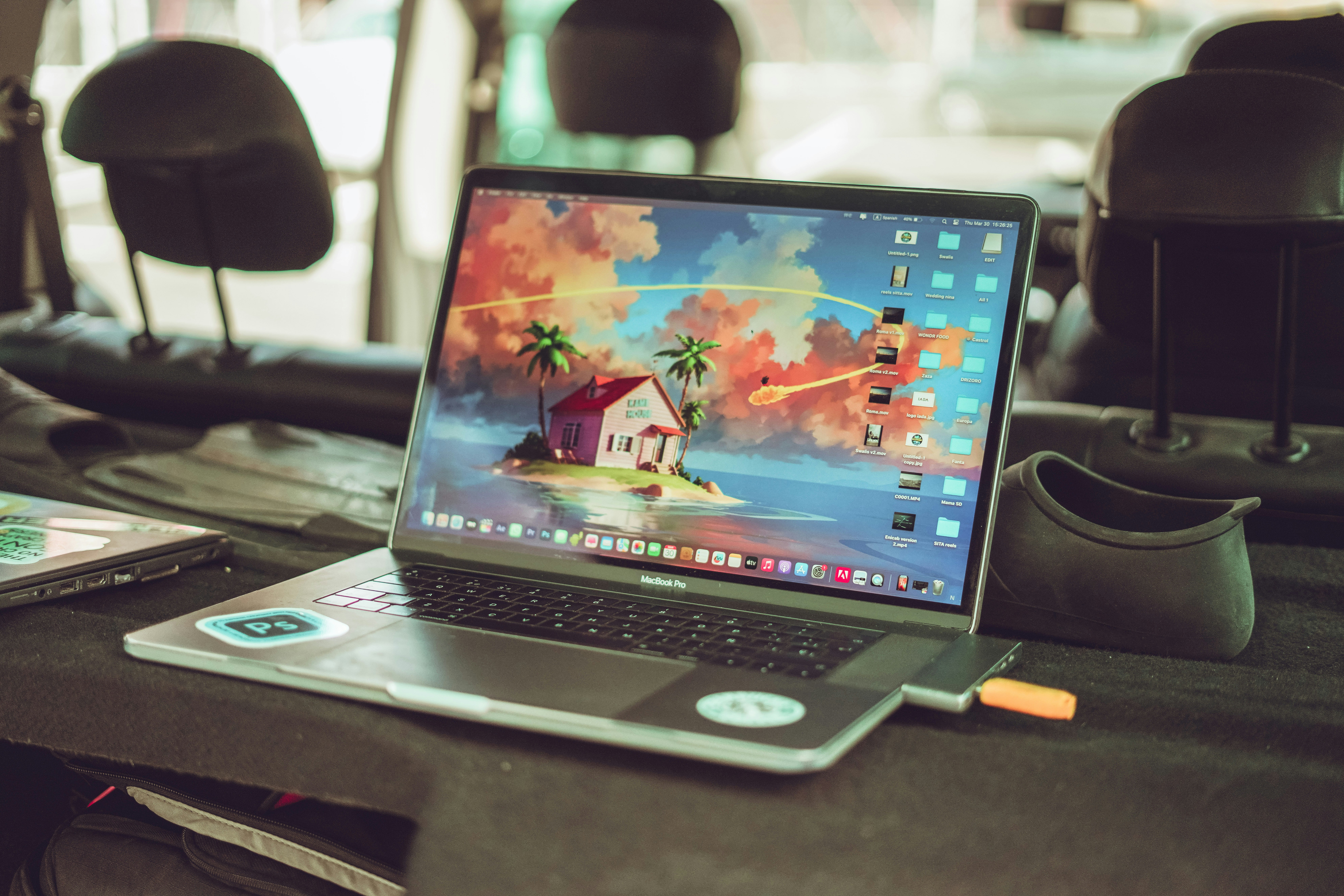 Technician using a diagnostic laptop connected to an electric vehicle in a service bay