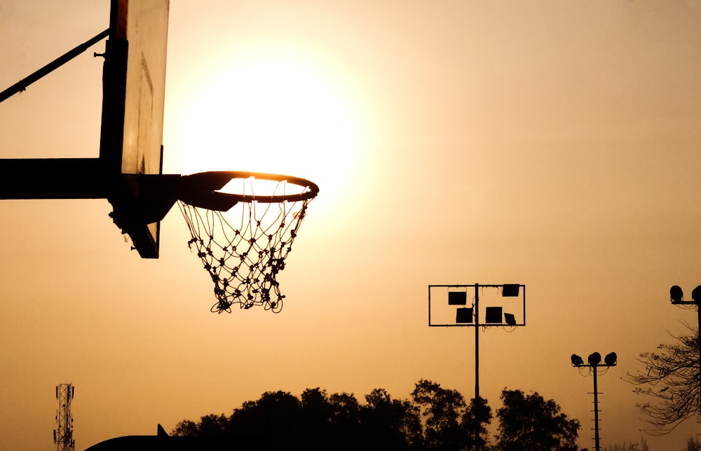 a basketball hoop with the sun in the background