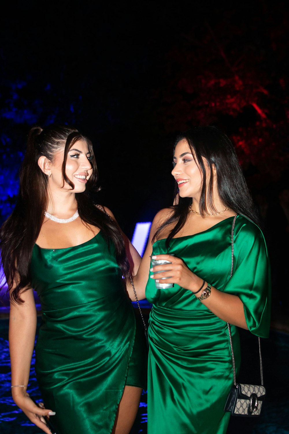 two women in green dresses standing next to each other