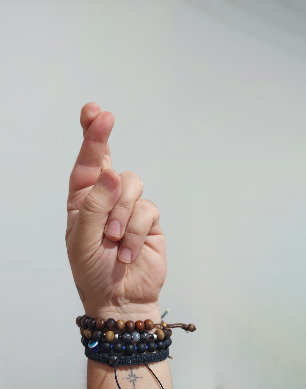 a person wearing a bracelet with a peace sign on it