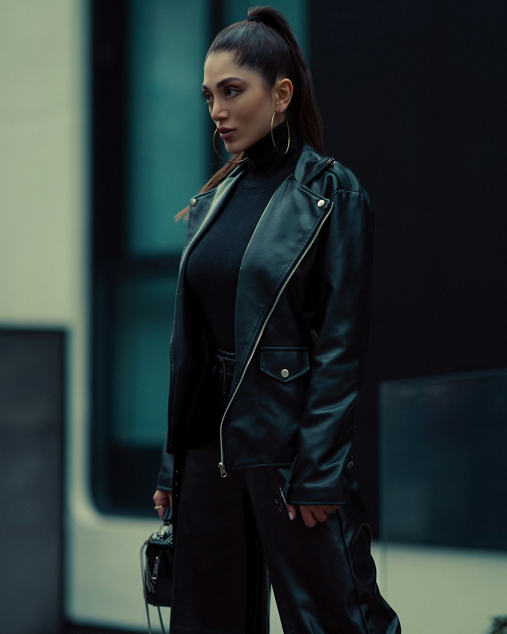 a woman wearing a black leather jacket and black pants