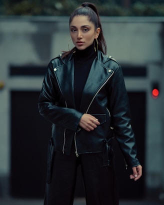 a woman wearing a black leather jacket and black pants