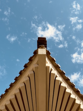 Several bundles of shingles laid out on a pallet with a clear, bright sky overhead.