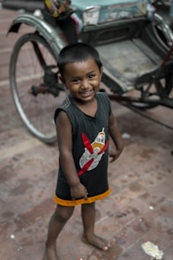 a young boy is standing in front of a cart