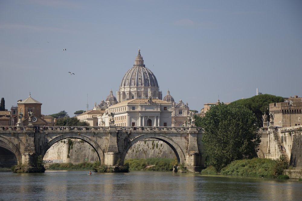 a bridge over a body of water with a building in the background