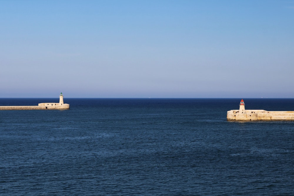 two lighthouses in the middle of a large body of water