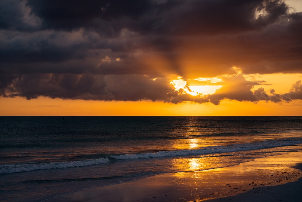 Il sole sta tramontando sull'oceano in una giornata nuvolosa