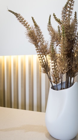 An entryway display featuring a sleek vase with fresh cut flowers against a minimalist backdrop.