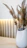 Elegant shot of a minimalist vase on a wooden shelf with soft beige walls in the background.