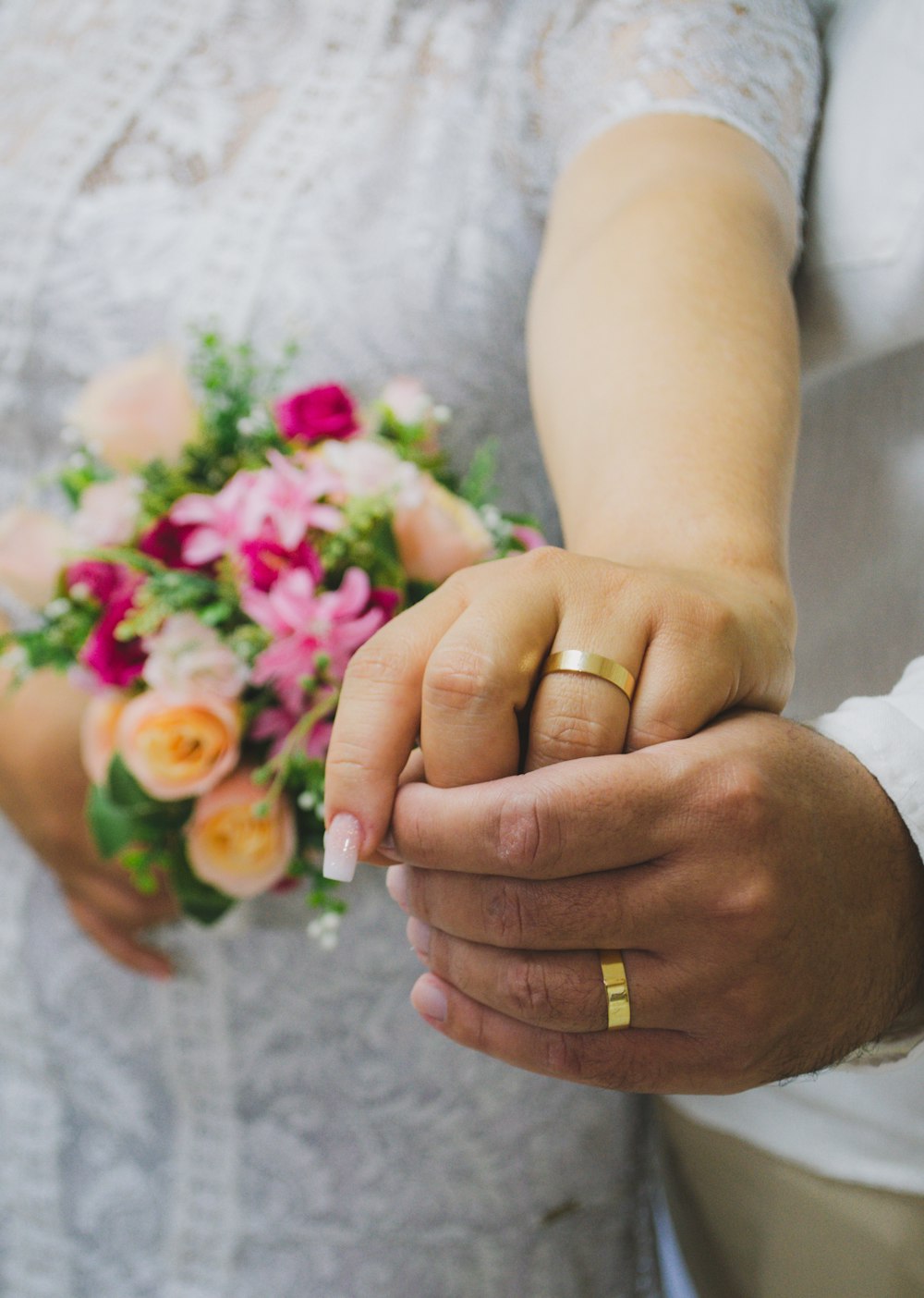 a close up of a person holding a bouquet of flowers