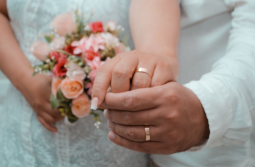 a close up of a person holding a wedding ring