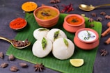 Traditional South Indian snacks arranged on a banana leaf background.