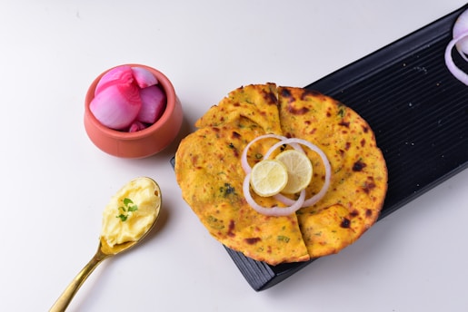a flatbread with onions and a lemon on a plate
