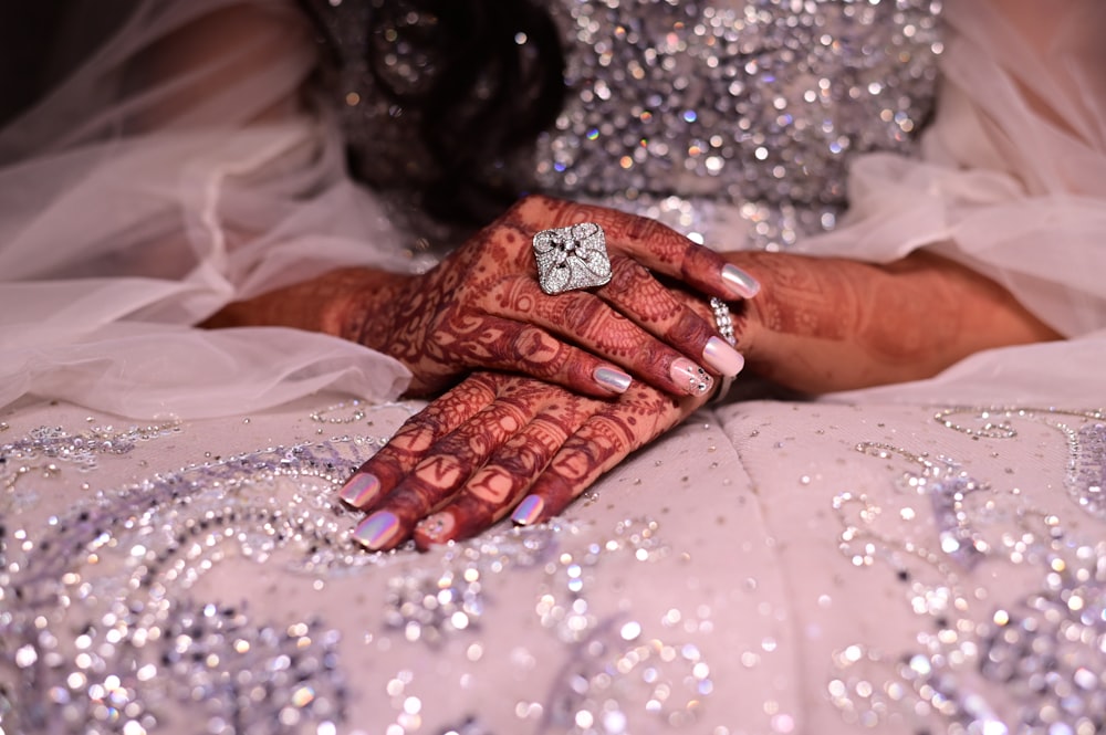 a close up of a person's hands holding a diamond ring