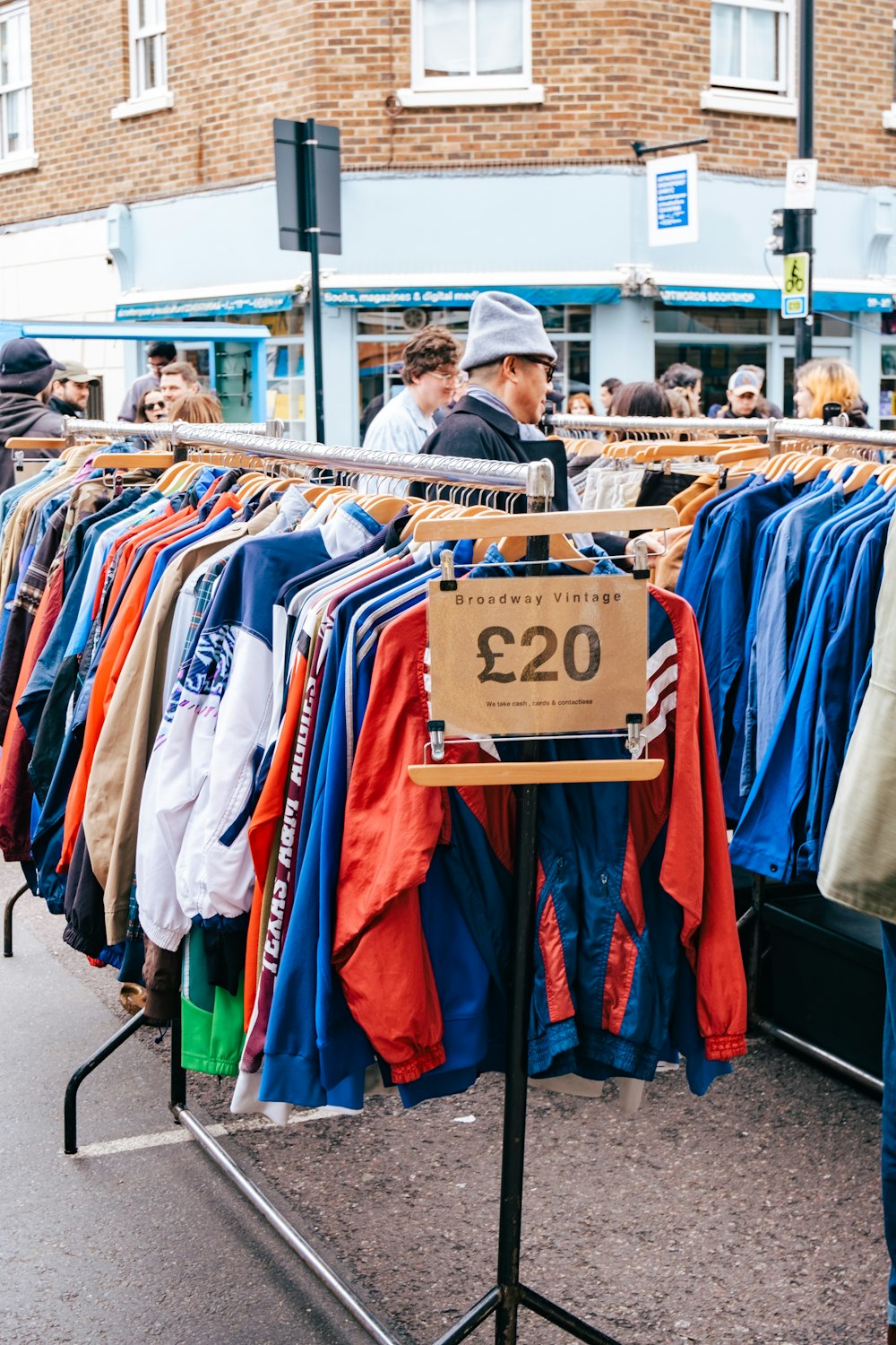 a man standing in front of a rack of shirts