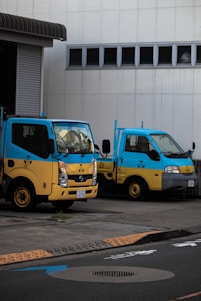 A fleet of small trucks parked in front of a warehouse, ready for loading and transport.