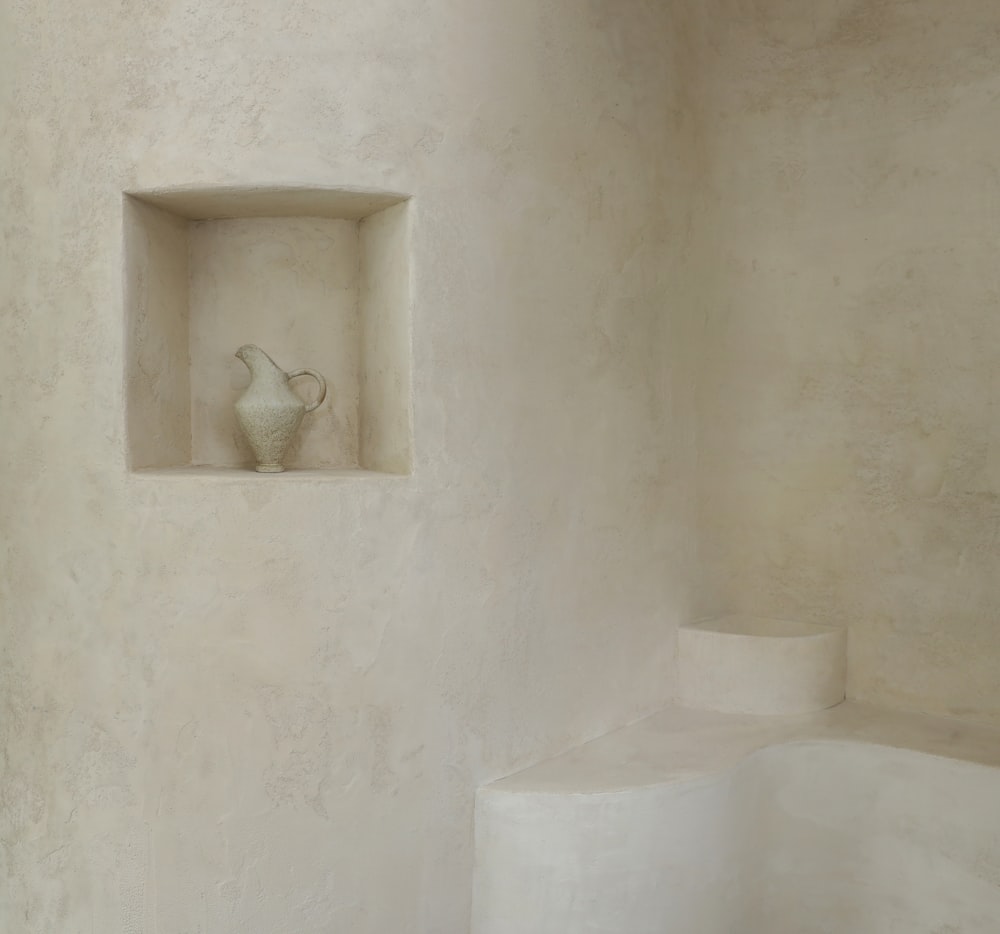 a white vase sitting in a niche in a wall