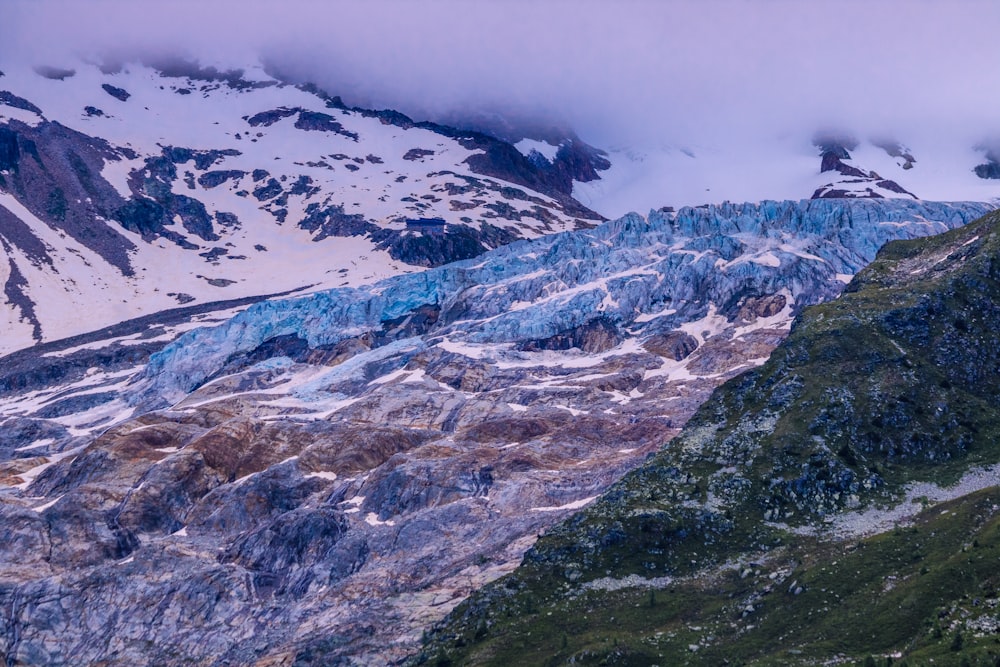 a group of mountains covered in snow and clouds