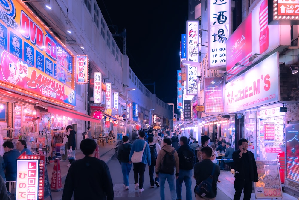 a group of people walking down a street at night