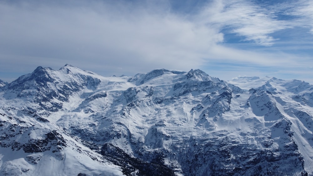 uma vista de uma cordilheira nevada do topo de uma montanha