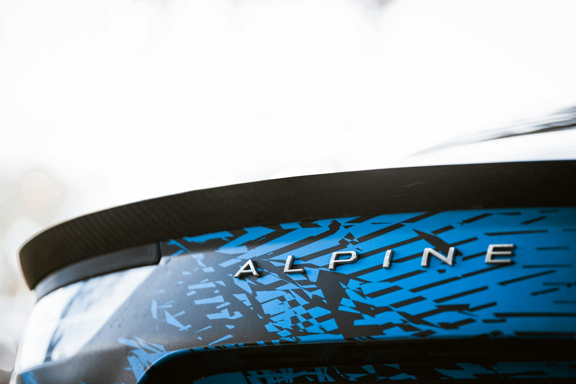 a close up of a blue and black car with the word alpine on it