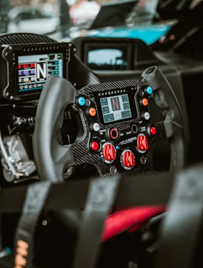 A close-up of a racing car's steering wheel and dashboard.