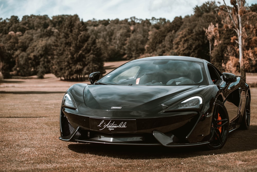 a black sports car parked in a field
