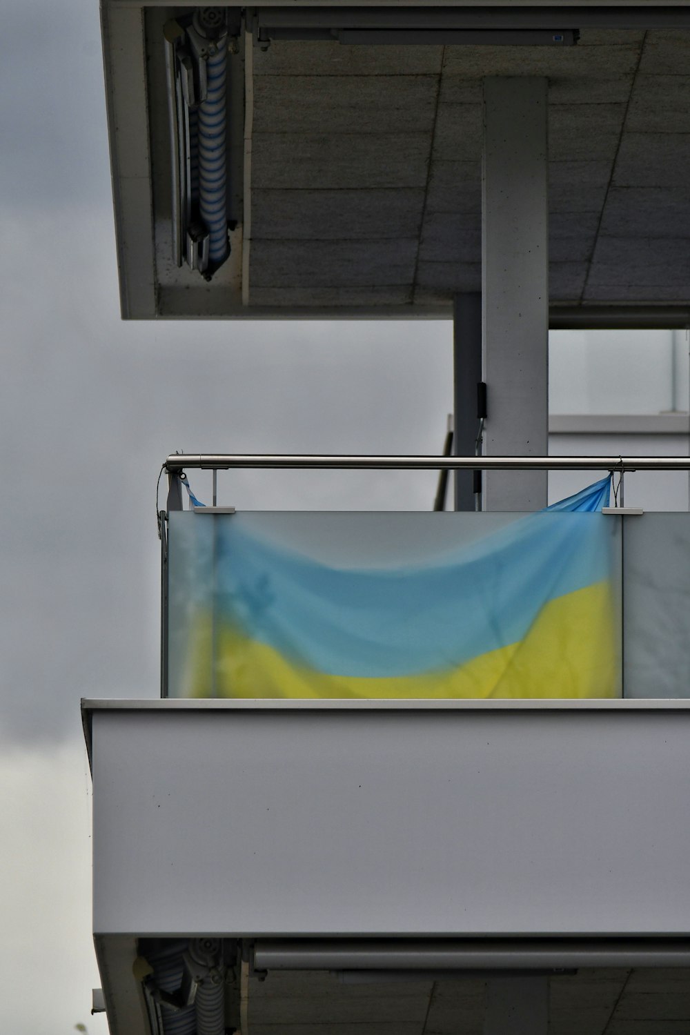 a blue and yellow flag hanging from a building