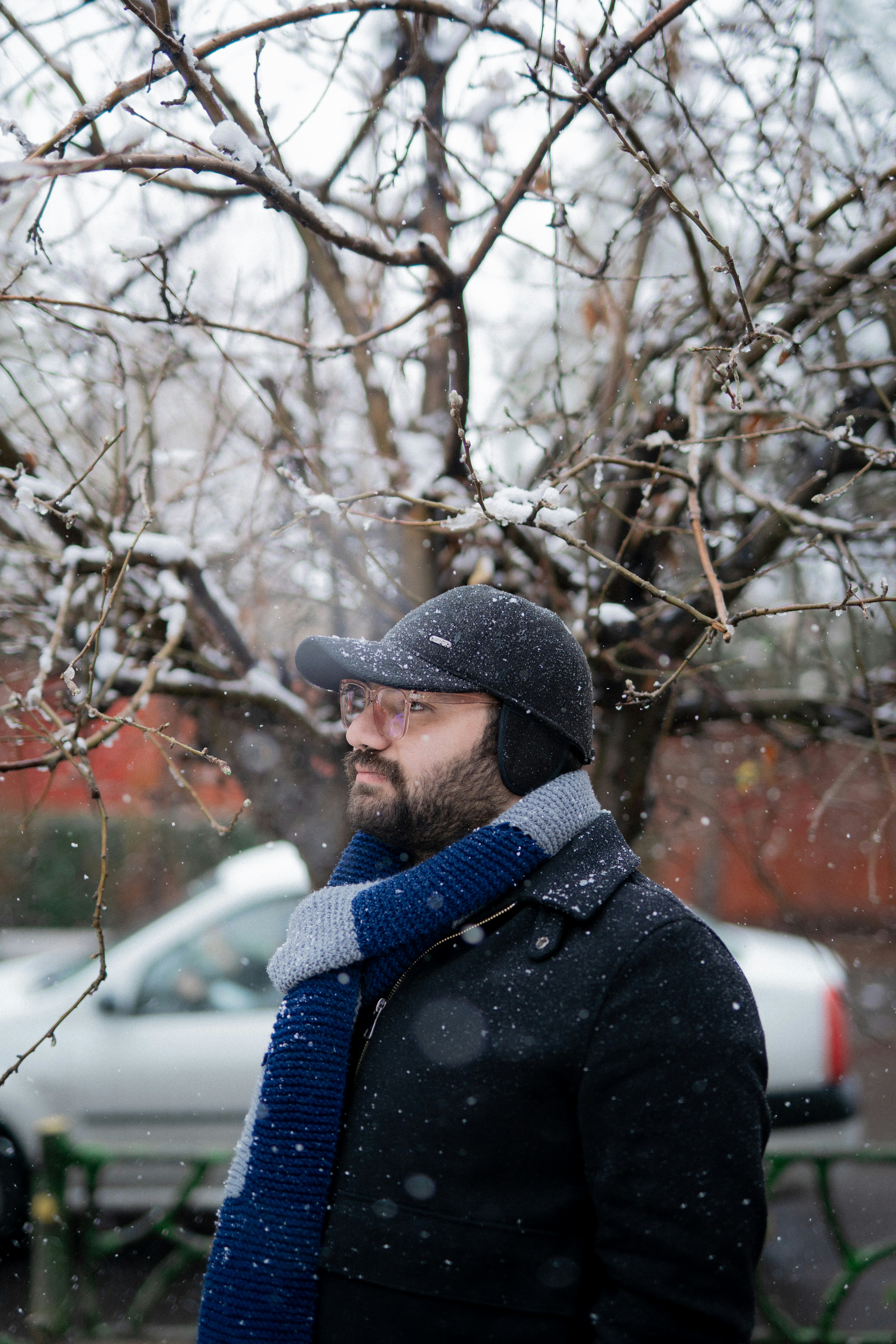 a man standing in front of a tree covered in snow