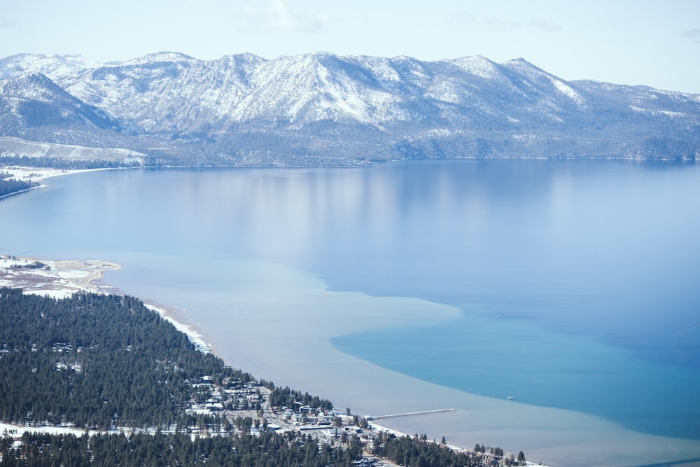 a large body of water surrounded by snow covered mountains