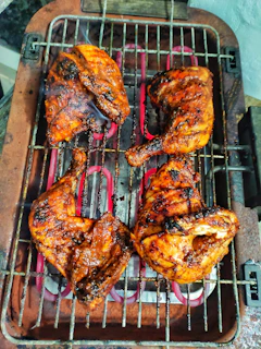Golden smoked chicken quarters fresh off the grill with herbs and spices visible