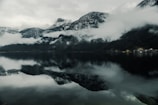 A serene lake reflecting snow-capped mountains in southern Chile at sunrise.