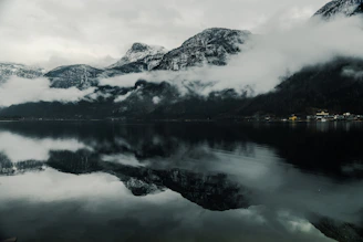 Snow-capped mountains and serene Dal Lake reflecting houseboats in Kashmir.