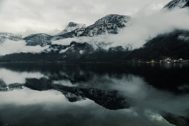 A serene lake reflecting snow-capped mountains in southern Chile at sunrise.